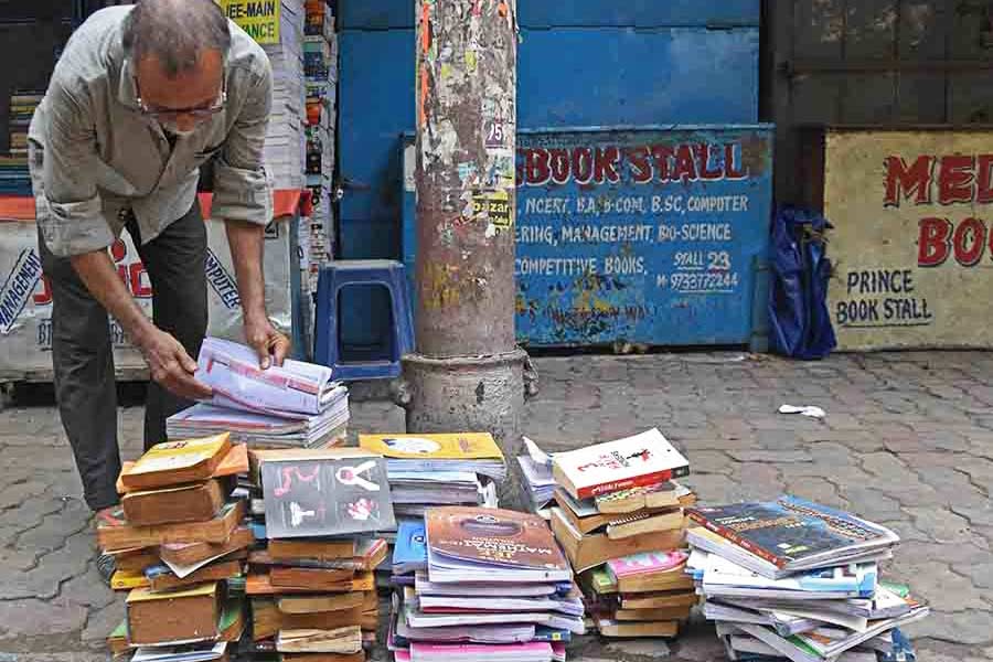 The owner of a books stall in College Street ‘Boipara’ puts books out to dry in the sun on Tuesday. The entire stretch had been waterlogged since Sunday night owing to incessant rainfall triggered by the cyclone  