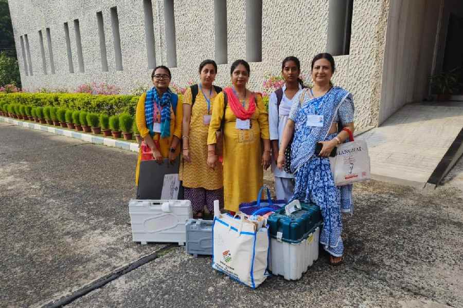 Women officials with their EVM and other equipment before entering the booth at the National Dairy Development Board in DK Block