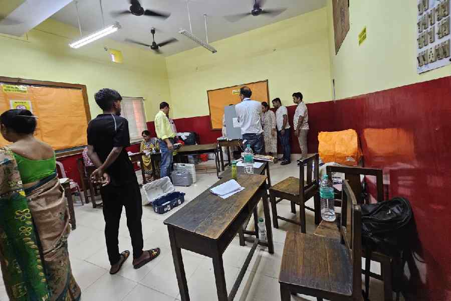Officials try to repair the damaged electronic voting machine at Bharatiya Vidya Bhavan