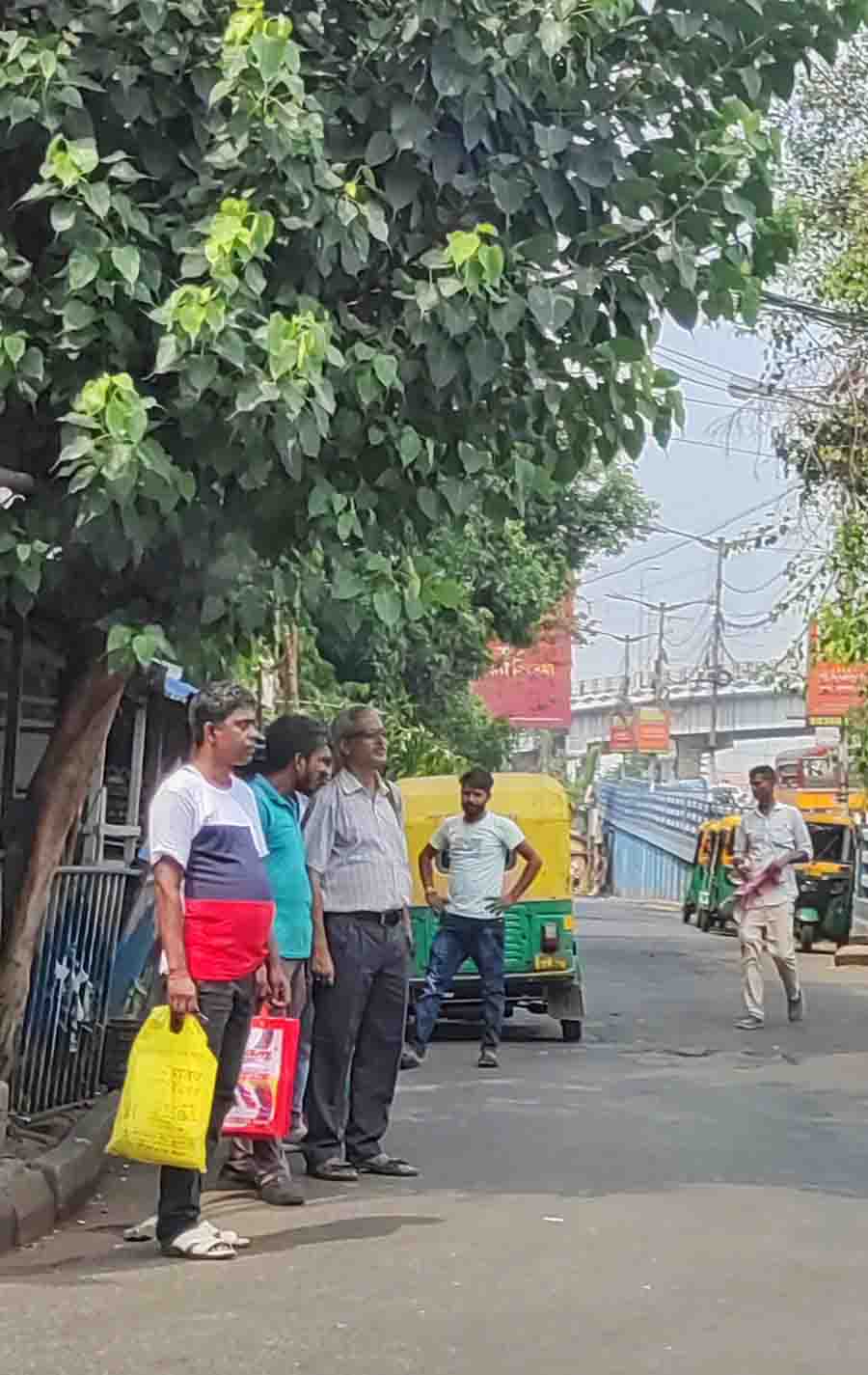 Commuters wait under the shade of a tree amid scorching temperature of around 37ºC, which coupled with the high humidity felt much higher on the skin