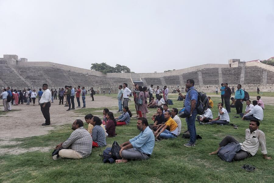 People evacuated from the mall building watch the firefighting from the safety of the Geetanjali stadium grounds