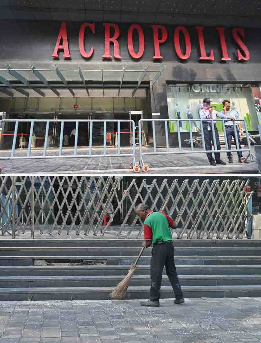 A worker cleans the forecourt of Acropolis Mall in Kasba’s Rajdanga, which has been shut down indefinitely after a fire broke out on Friday. Timely evacuation helped 15 fire tenders to contain the blaze and avert a tragedy 