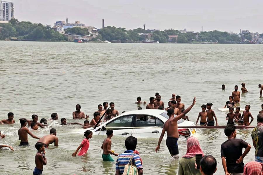 Local residents help pull out a car that fell into the Hooghly river with a boy inside on Sunday morning. The boy had allegedly fiddled with the steering wheel, causing the vehicle to roll into the river. Prompt action by onlookers helped save the child 