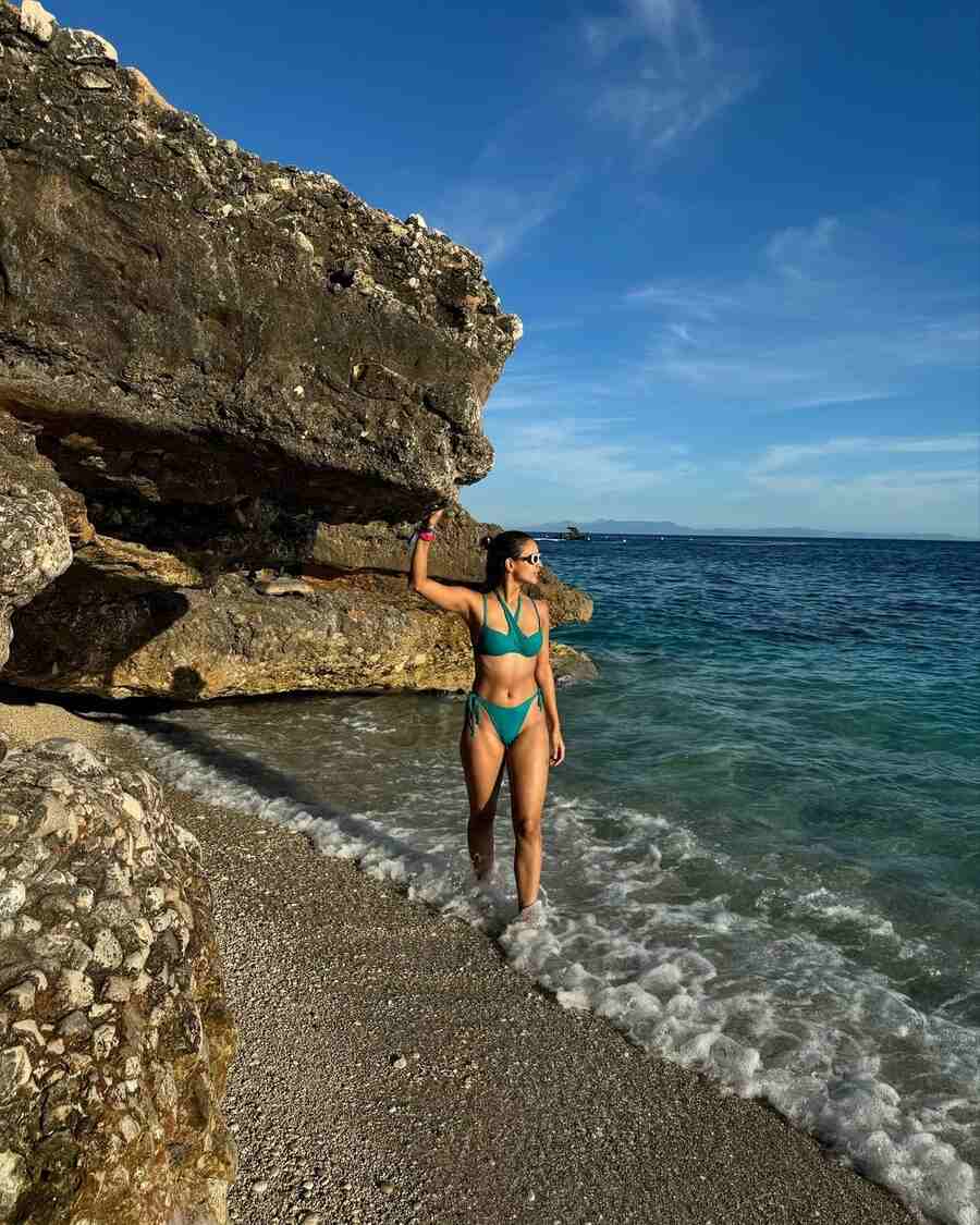 Triptii strolled along the beach in a blue bikini while the ocean blending into the horizon made for a stunning backdrop.  