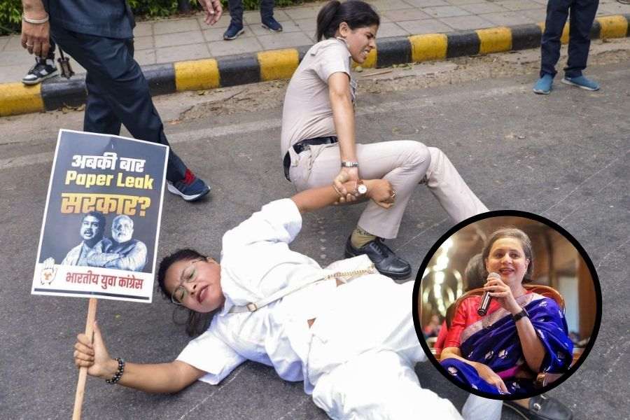 A policewoman detains a member of the Indian Youth Congress during the protest outside Union education minister Dharmendra Pradhan’s residence in New Delhi on Thursday.