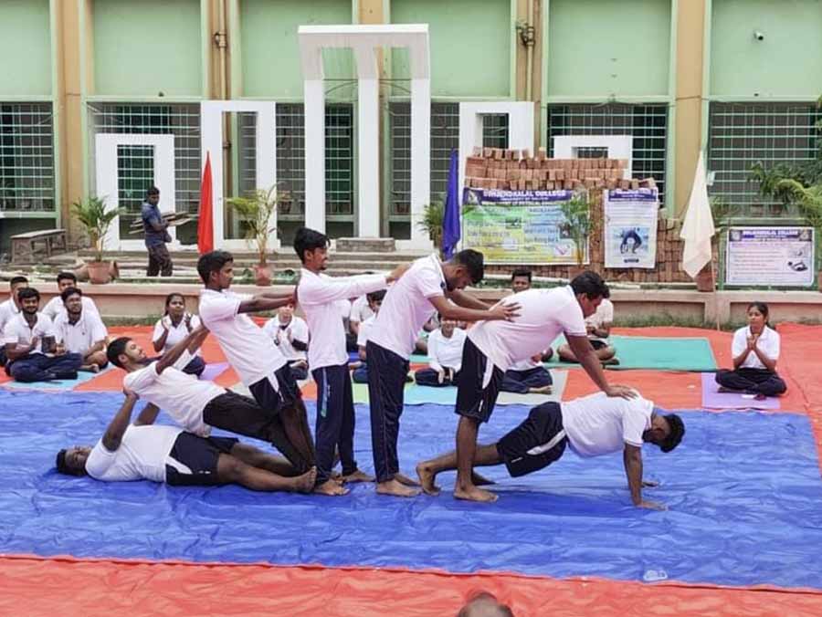 Students of physical education department of Dwijendralal College, Krishnanagar, perform yoga 