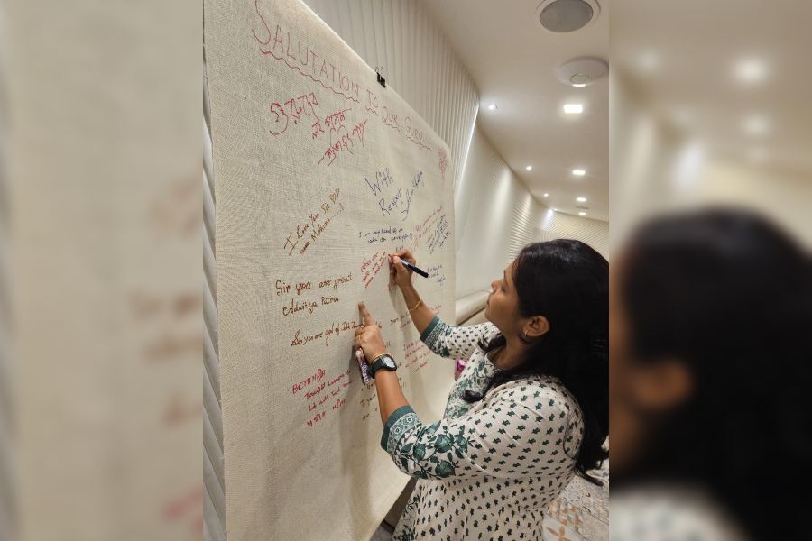 Olympian Mouma Das writes her salutation message for her coach Jayanta Pushilal on a board put up at the programme.