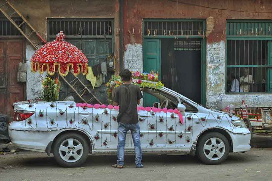A florist decorates a bridegroom’s car on a north Kolkata street on Saturday