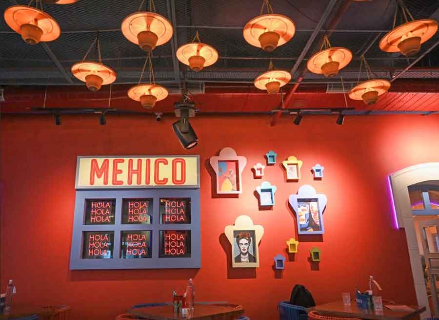 The walls are decked up with traditional Mexican art with framed pictures, neon “Hola” signs and a large ‘Mehico’ sign