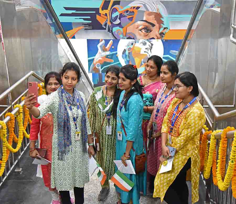Bright and colourful murals on way to the platform provide the perfect backdrop for groupfies for this bunch of first passengers 