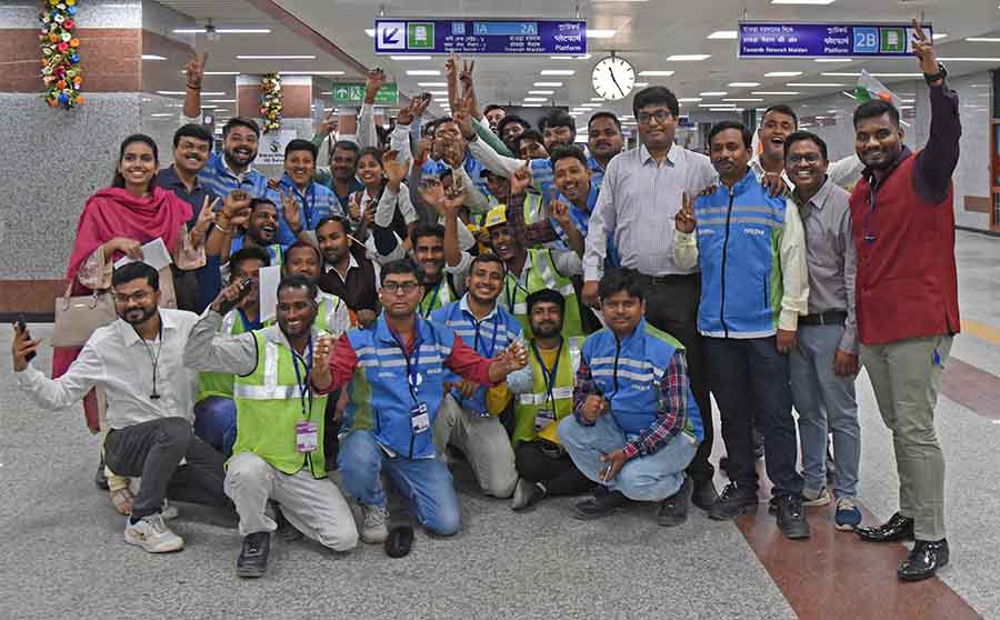 Kolkata Metro Railway Corporation Limited employees pump fists in the air and flash the victory sign after Prime Minister Narendra Modi formally inaugurated the Green Line 