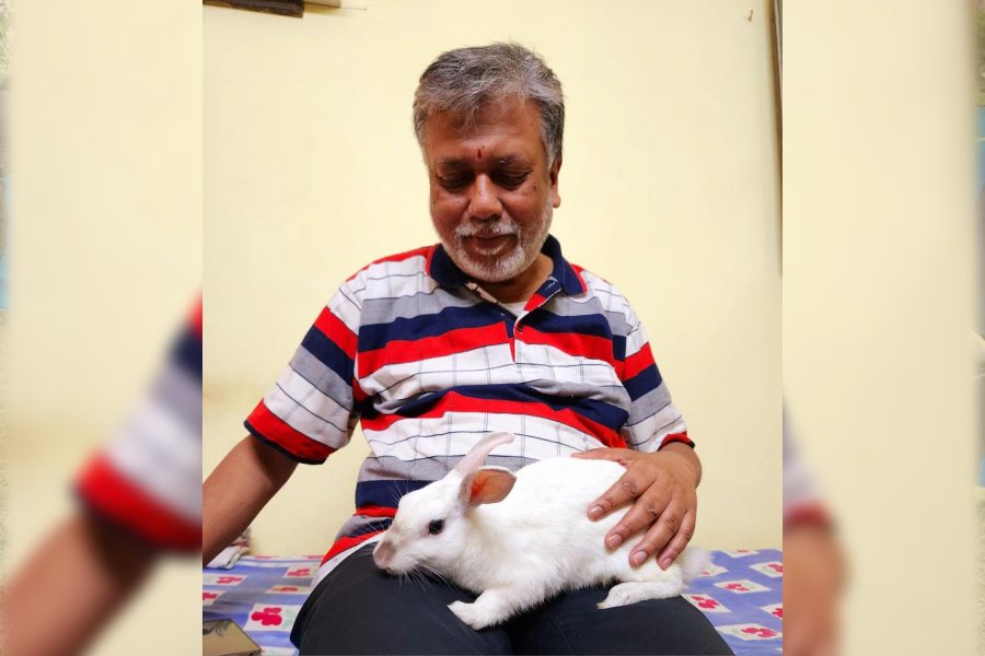 Bhutu the rabbit rests on Joy Dasgupta’s lap.