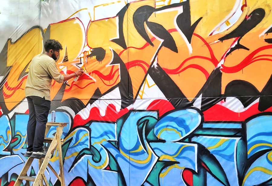 An artist busy painting a wall graffiti at Jodhpur Park on Saturday