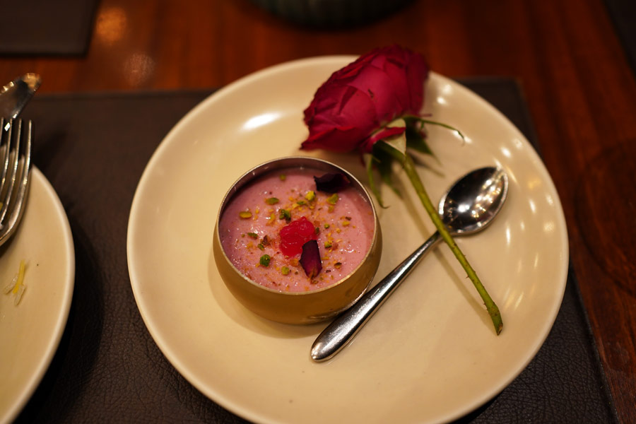 Dessert came with a touch of Nawabi romance. Shirni Nawab, a dried rose petal kheer topped with pistas, was served with a fresh single-stem rose that added to the beauty of the pink kheer in a bowl