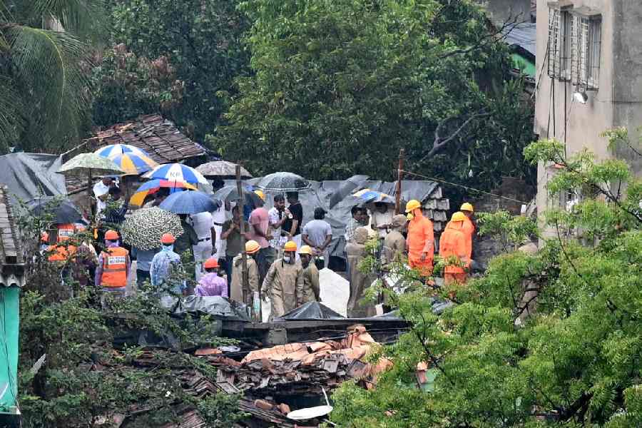 Rescue workers at the collapse site amid rain on Wednesday.