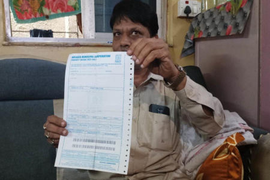 Sanawar Ali, the owner of the Garden Reach building, shows a tax bill on Thursday. (Right) A room inside the building. The owner said this portion has a kitchen and toilets on all floors