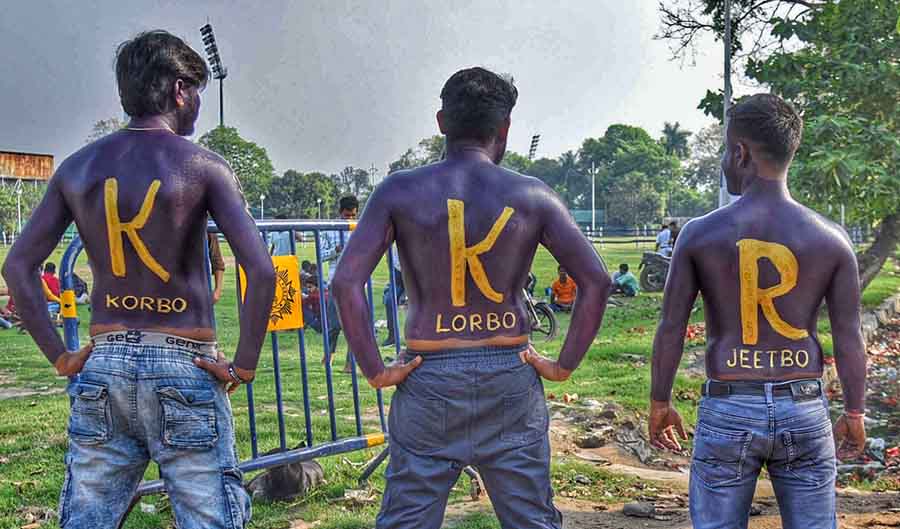 Three young men show off their passion for the Kolkata Knight Riders with body painted in team colours and team slogan ‘Korbo, Lorbo, Jeetbo’