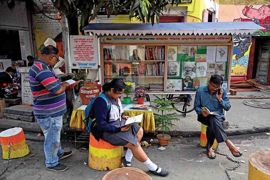 People of all ages read books at the street library
