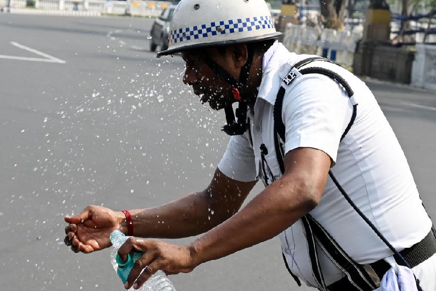 A traffic cop splashes water on his face on Mayo Road on Friday afternoon. The day’s maximum temperature was 35 degrees.