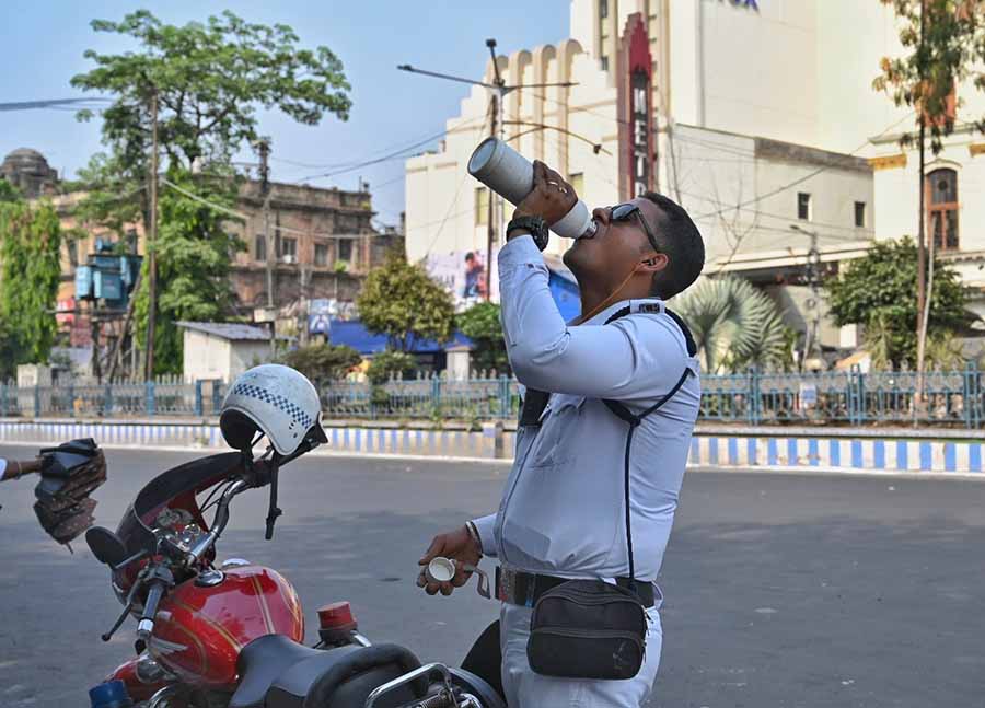 A traffic cop drinks water while on duty under the sweltering sun on Wednesday. Staying hydrated is important to stay safe from heatstroke, especially for those working outdoors 