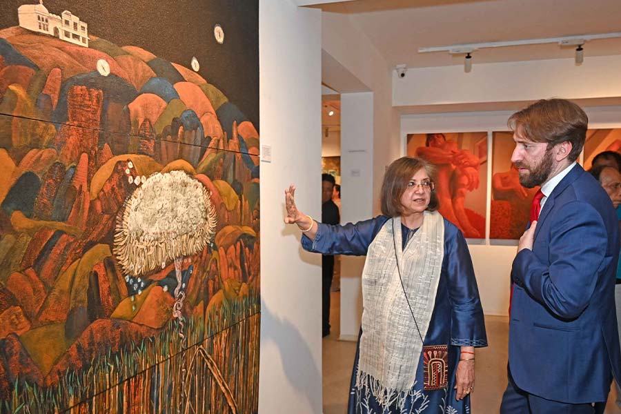 Rakhi Sarkar shows Riccardo Dalla Costa the 2006 work by Rashmi Bagchi Sarkar, Hope for a Flower Float, Iwa-enogu, stone pigment, natural glue over cotton stretched on panel (triptych), 77.6 x 48 inches