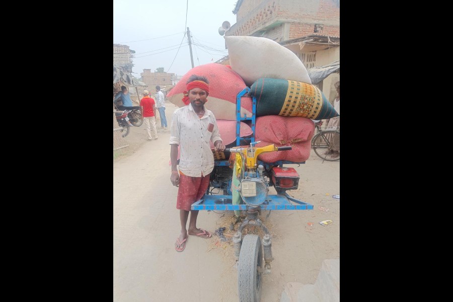 Mukesh Paswan with the improvised vehicle on which he carries goods to eke out a living.