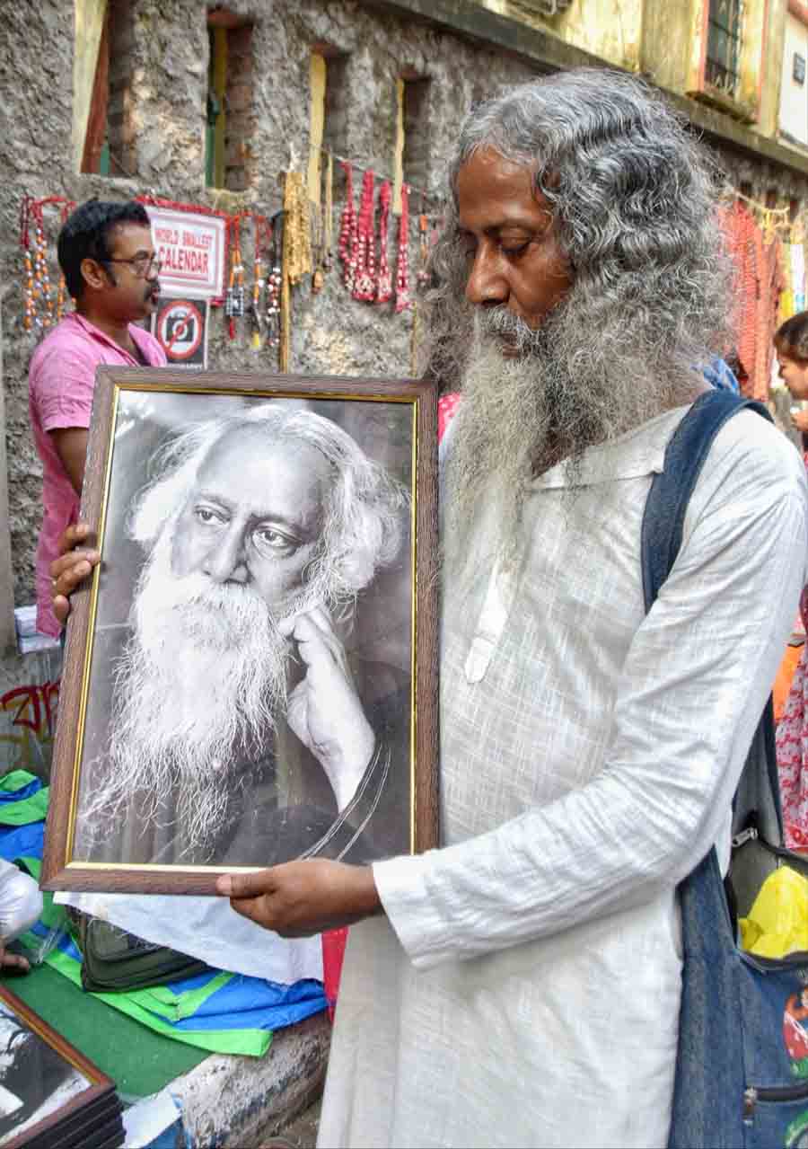 Rabindranath Tagore’s doppelganger holds a photograph of the bard at the mela outside Thakurbari