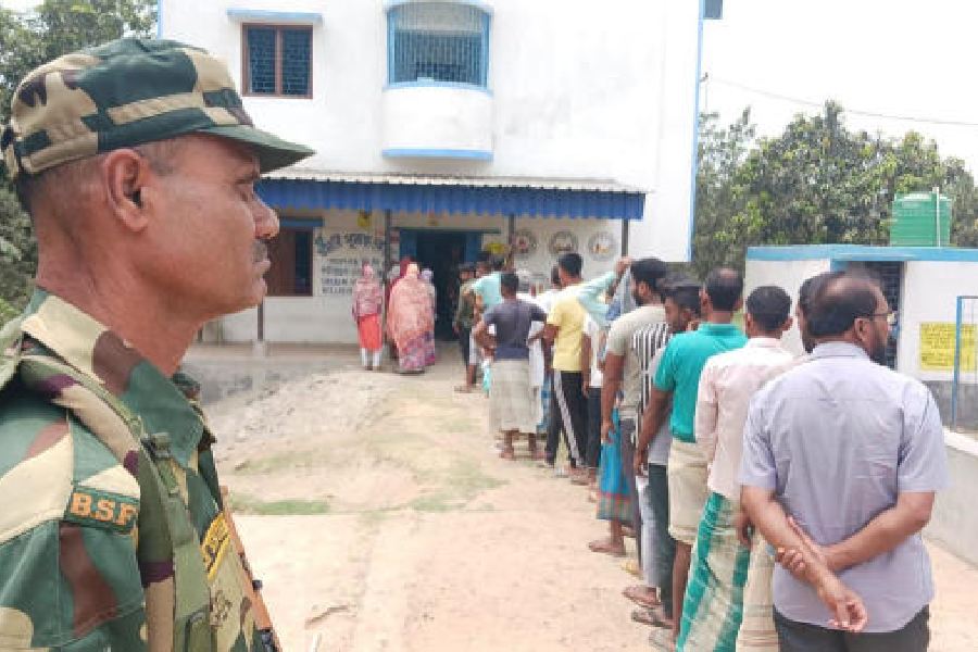 Voters queue up at a polling booth in Shoshani near the Bangladesh border in the Malda Dakshin Lok Sabha constituency on Tuesday