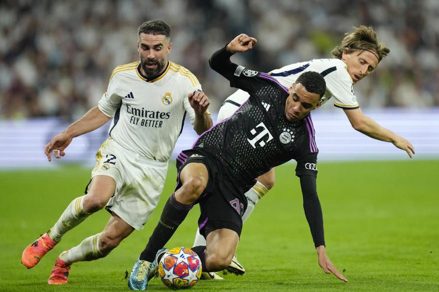 Bayern's Jamal Musiala, centre, challenges for the ball with Real Madrid's Luka Modric, right, and Real Madrid's Dani Carvajal during the Champions League semifinal second leg soccer match between Real Madrid and Bayern Munich at the Santiago Bernabeu stadium in Madrid, Spain, Wednesday, May 8, 2024.