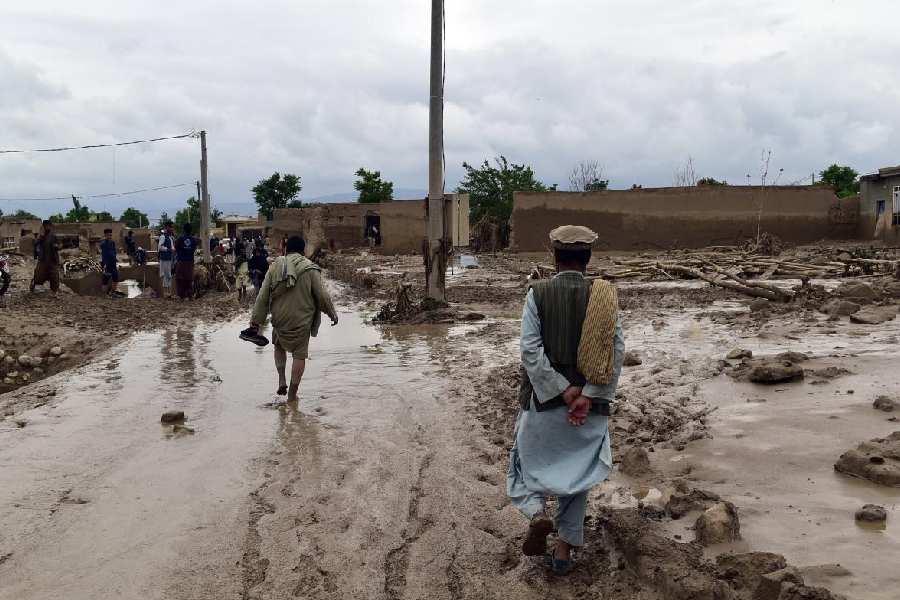 People are seen near to their damaged homes after heavy flooding in Baghlan province in northern Afghanistan