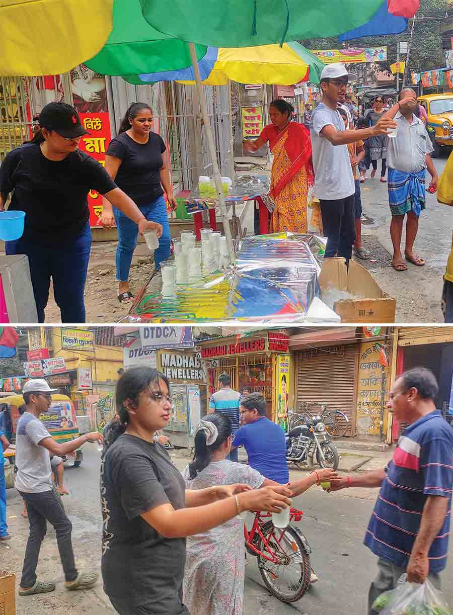 Youths at Deshbandhu Nagar, Baguiati, and their parents distributed water and biscuits among pedestrians to help them beat the heat on Sunday   