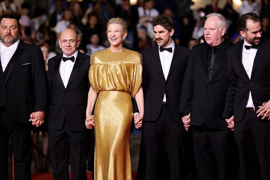 Cate Blanchett exuded radiance in a Louis Vuitton cape gown, hand embroidered with minuscule glass tubes made of gold and featuring crystal-embellished shoulders. The actress, who received a four-minute-long standing ovation for her film Rumours, completed her look with gold sandals and statement jewellery. 