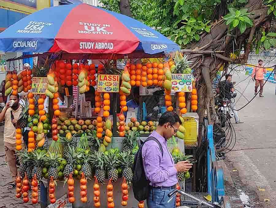 Passers-by make the most of a nicely decorated fruit juice stall at Park Street to sip and chat on Tuesday