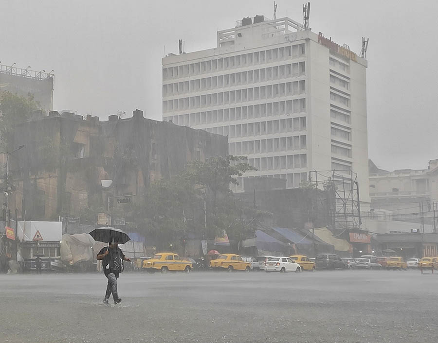 A solitary man braves blinding rain with an umbrella at Esplanade 