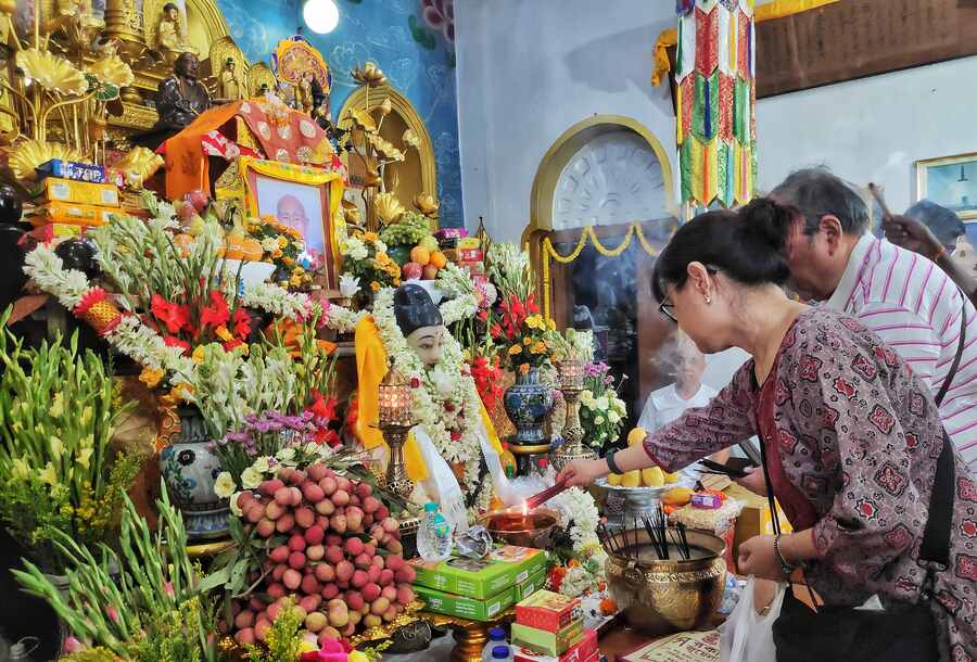 Devotees offer garlands and incense sticks to flower-bedecked idols of Lord Buddha at the Nipponzan Myohoji Buddhist temple near Dhakuria bridge on Thursday morning