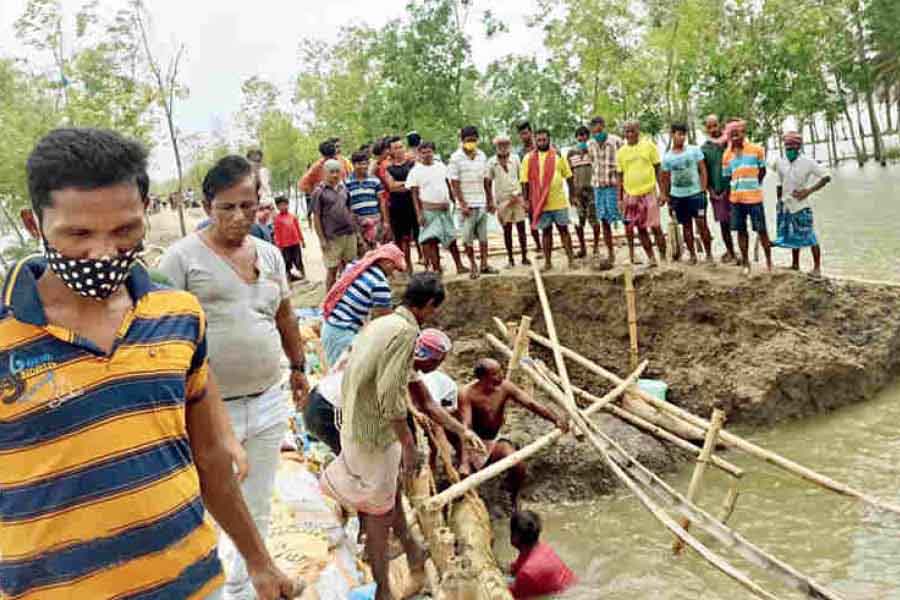 Villagers try to repair a breached embankment at Patharpratima in South 24-Parganas on Thursday, a day after Cyclone Yaas in 2021.