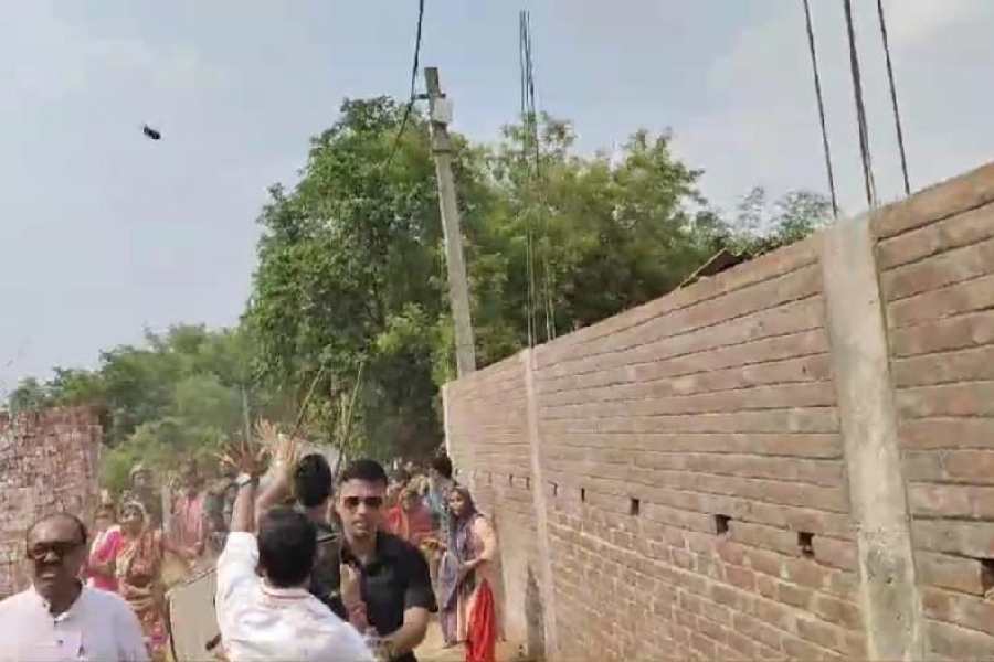 A central force jawan tries to protect Jhargram BJP candidate Pranat Tudu (wearing a white kurta) from the mob at Garbeta in Jhargram on Saturday.