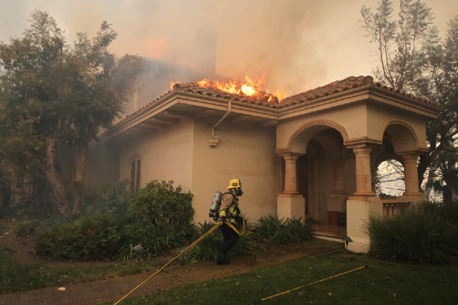 A firefighter at work, as smoke billows from the Mountain Fire in Camarillo, California, U.S. Reuters