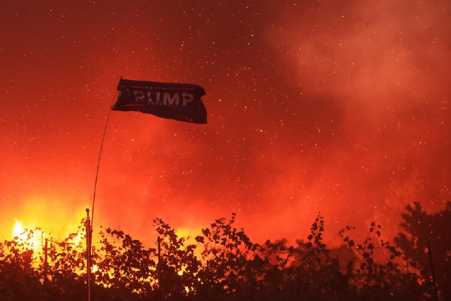 Amid fire, a flag in support of the U.S. President-elect Donald Trump. Reuters