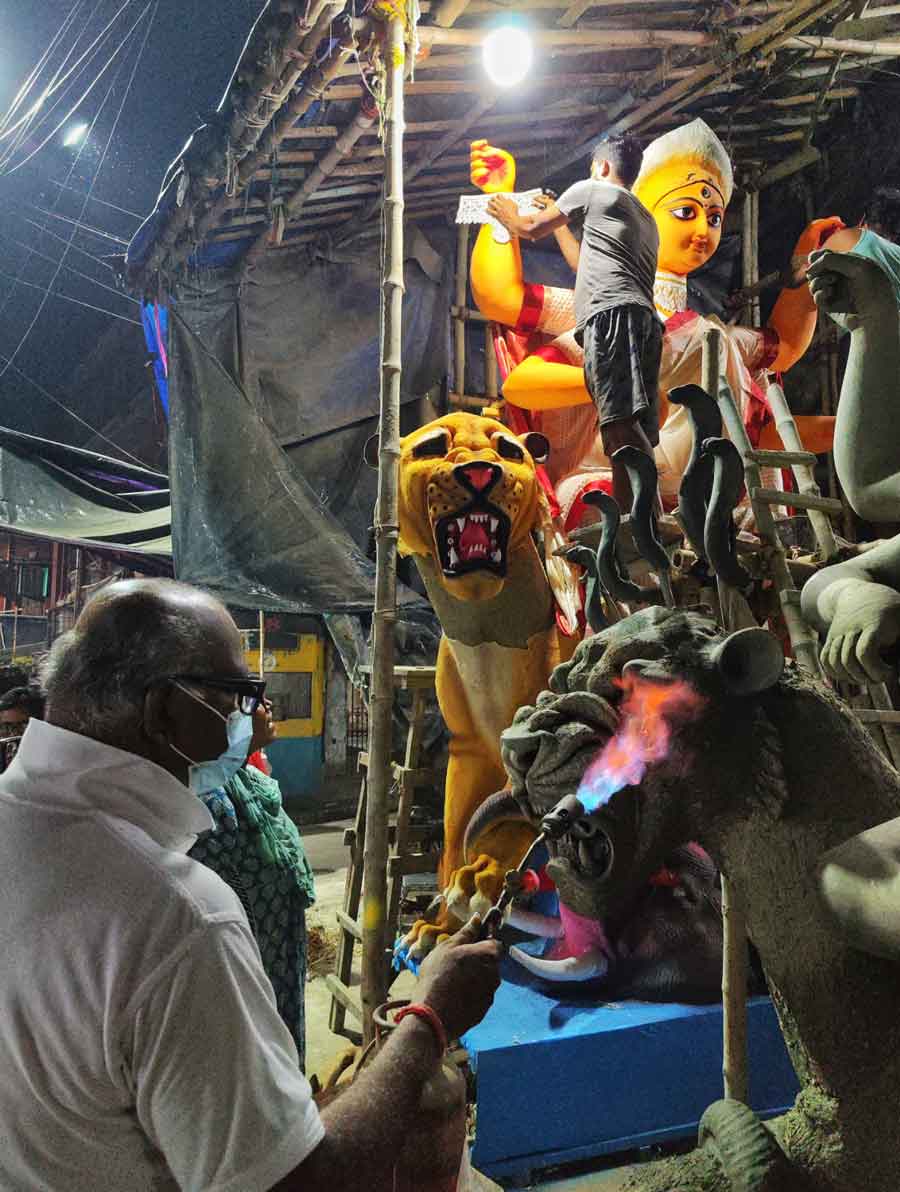 An idol maker dries a Jagaddhatri idol with a fire torch. The Puja in Kolkata commences from Ashtami which falls on November 10