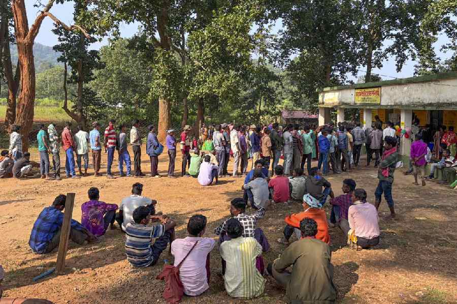 Voters wait at a polling station to cast their votes during the first phase of Jharkhand Assembly elections, at Chaibasa in West Singhbhum district of Jharkhand, Wednesday, Nov 13, 2024.