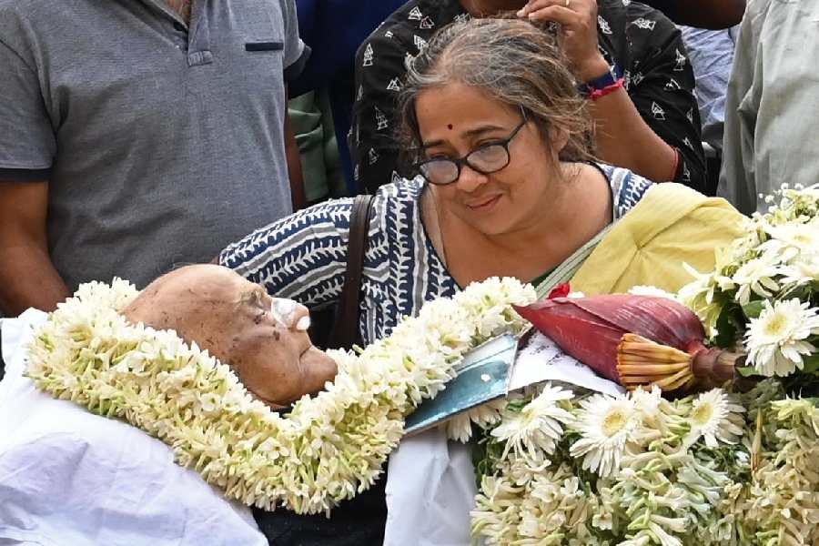 Daughter Mayuri casts a loving glance at Manoj Mitra as his body lies in state at Rabindra Sadan on Tuesday.