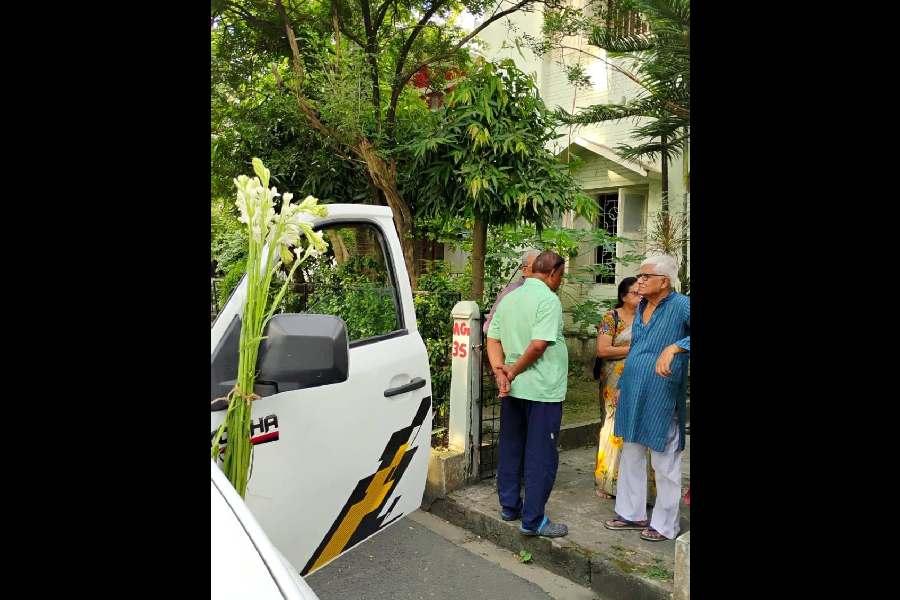The hearse carrying the mortal remains of Manoj Mitra from the hospital stops at his gate.
