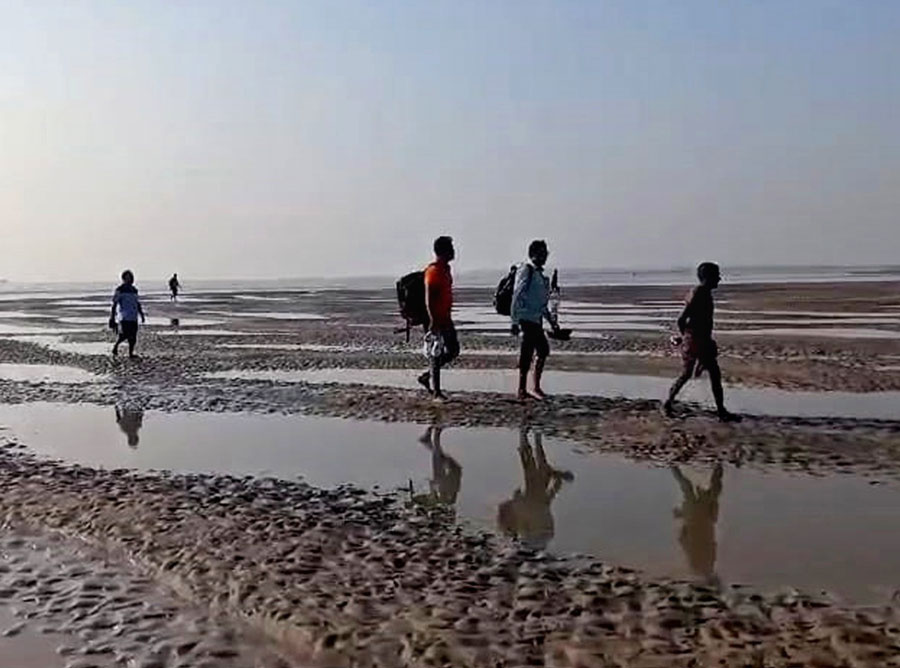 Heavy silting of the Muriganga river in Kakdwip. Commuters walk on the muddy riverbed to reach boats that will take them across the river. The district administration is planning to build a bridge for which marking and survey will soon begin   