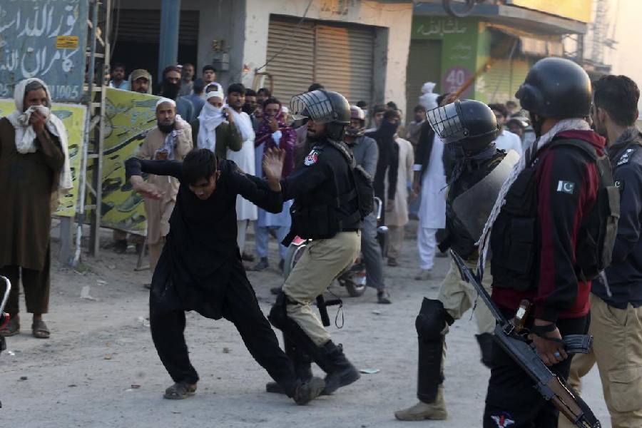 Police officers beat a protester who with others blocked a road near a police station in Peshawar. They were demanding that the police hand over an arrested man who was accused of insulting the Quran.