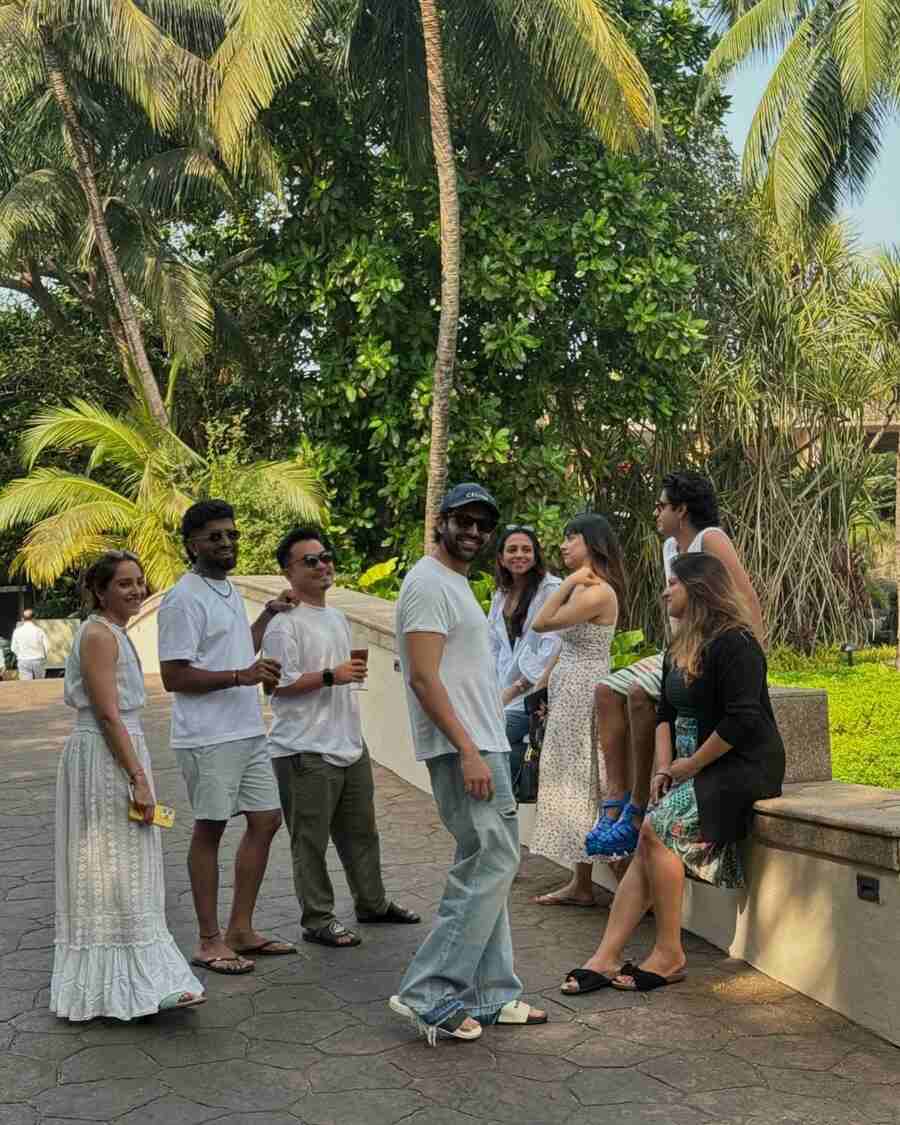 Sporting a white t-shirt, baggy ripped jeans and a cap, Kartik posed for a picture with his friends smiling in the background. 