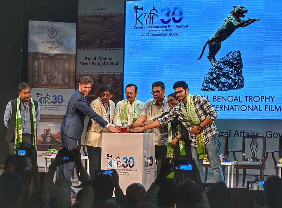 Alliance Française du Bengale director Nicolas Facino, KIFF chairman Goutam Ghose, KIFF chief adviser Aroop Biswas, festival co-chief adviser Indranil Sen, state forest minister Birbaha Hansda and actor Arjun Chakraborty unveil the Golden Royal Bengal Trophy for the 30th edition of the Kolkata International Film Festival at a news meet on Friday. Information and cultural affairs secretary Santanu Basu looks on at the far left end. The film festival will be held from December 4 to 11 