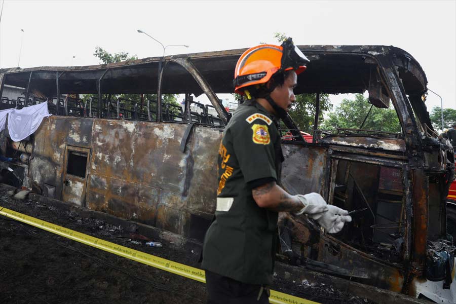 Firefighters work to extinguish a burning bus on the outskirts of Bangkok.