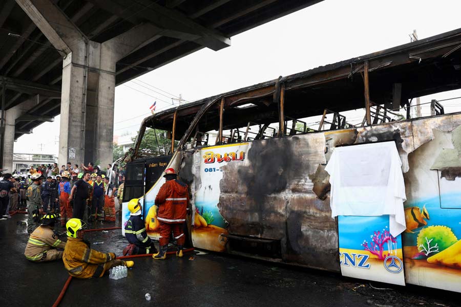 Firefighters work to extinguish a burning bus that was carrying teachers and students from Wat Khao Phraya school on the outskirts of Bangkok.