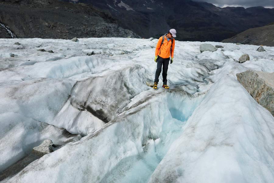 Glaciologist Huss looks at water flowing into a moulin on the Pers Glacier, in Pontresina.